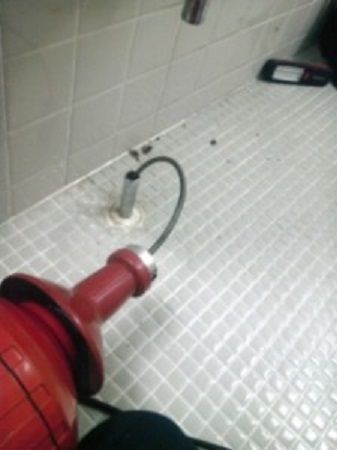 洗面所の排水管にワイヤーを挿入する