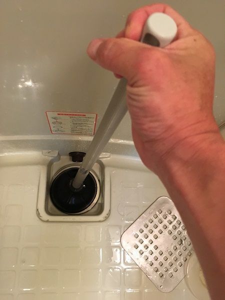 洗い場の排水口を器具で加圧する