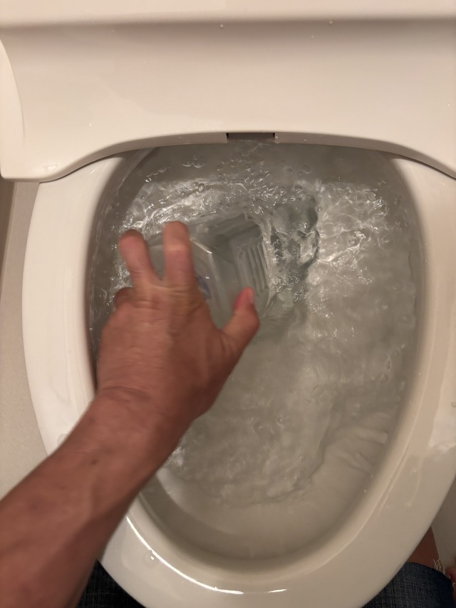 ペットボトルを便器に当てて上下に動かす